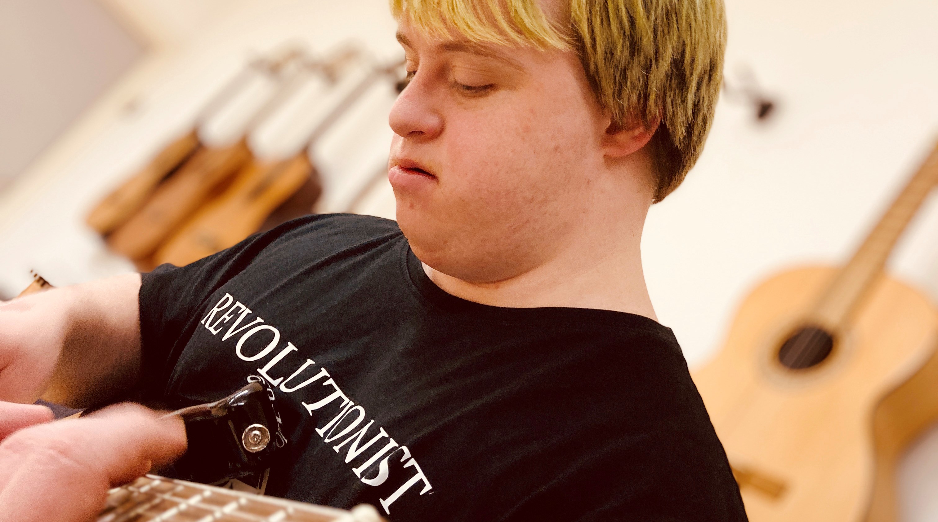 En person som spelar gitarr.