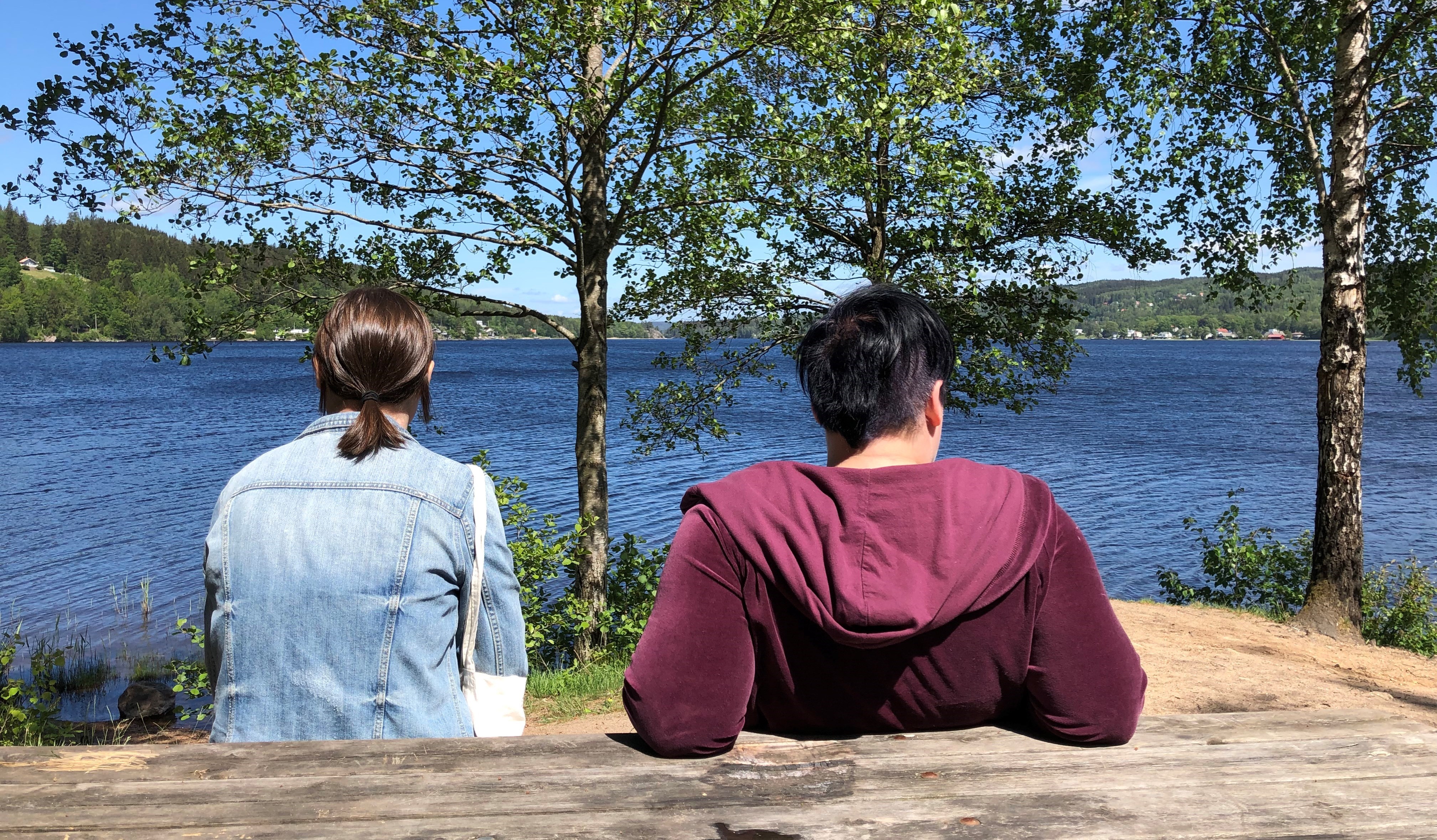 Två personer tittar ut över en sjö,