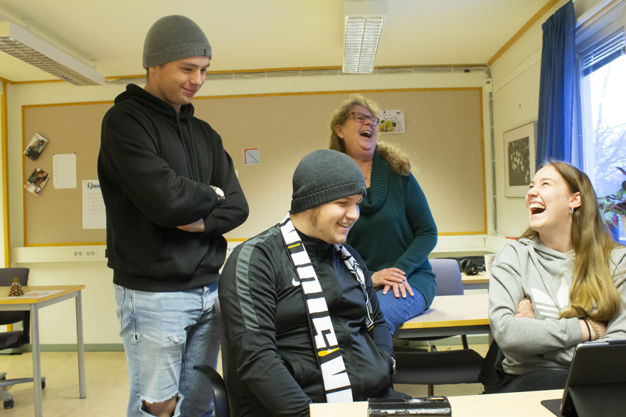 Deltagare tillsammans med lärare som skrattar i ett klassrum